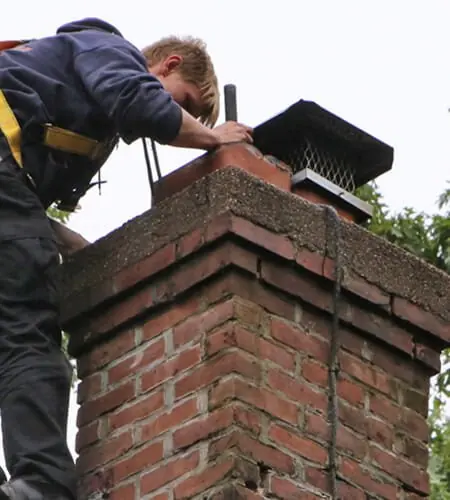 Lowes Chimney Sweep technician inspecting a residential chimney flue