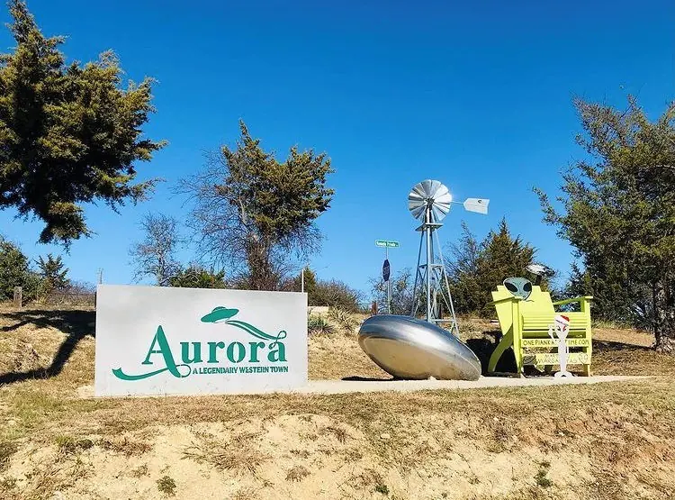 Aurora, Texas town sign with UFO monument and windmill