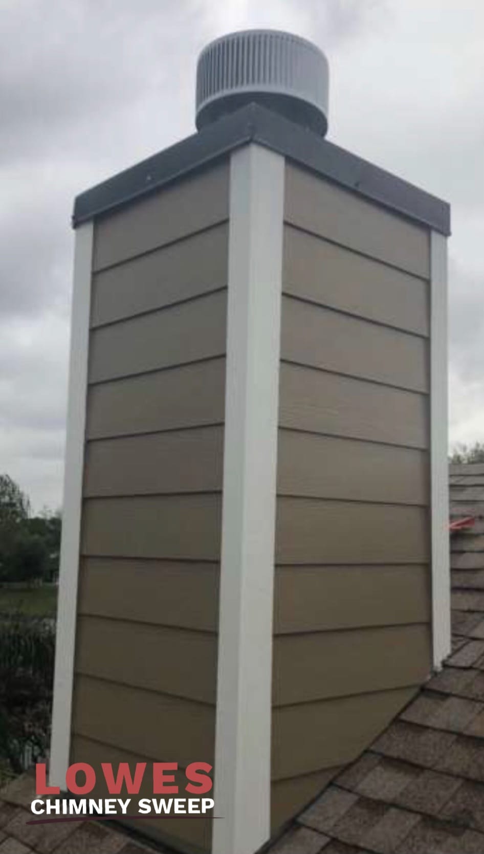 Completed chimney chase with new two-tone colour matched siding and caulking