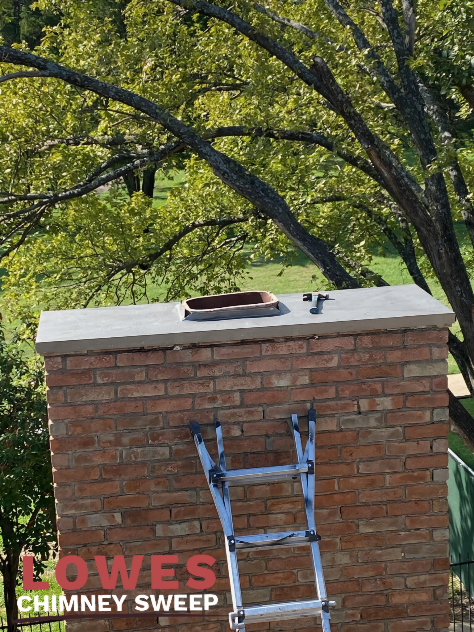 Metal chimney crown cover installed over masonry chimney top